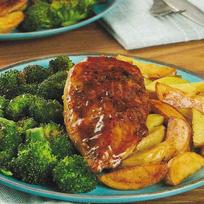 Glasierte Hähnchenbrust mit dunkler Honig-Balsamico-Sauce neben ofengerösteten Brokkoliröschen und Kartoffelspalten